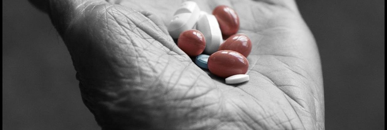 Nærbilde av piller i en eldre person sin hånd