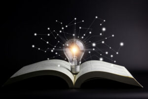Bilde av en åpen bok med en lyspære oppå med stjerner rundt
