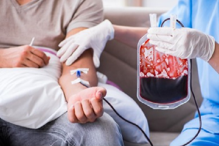 Person mottar blodprodukt via en veneflon i venstre arm