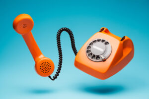 Oransje telefon med ledning.