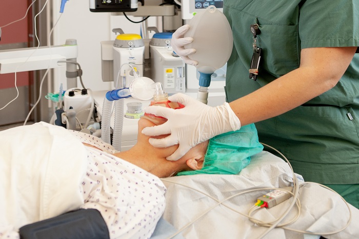 Anestesisykepleier som jobber med en bag-maskeventilasjon på en pasient i anestesi