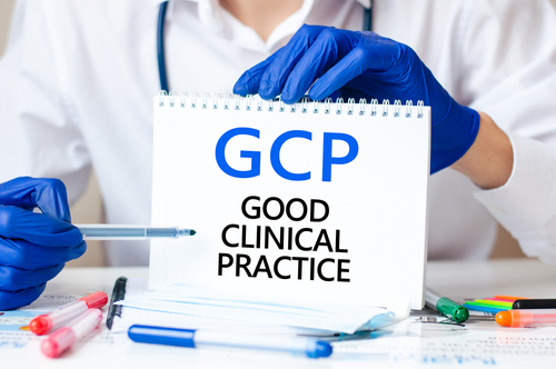 Fotografi av helsepersonell som peker på et ark hvor det står GCP (good clinical practice).