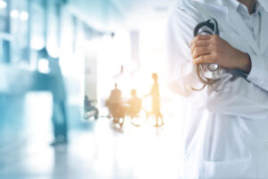 Lege i sykehuskorridor i hvit frakk med stetoskop