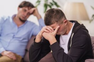 Ung mann sitter og snakker med lege Foto: Shutterstock