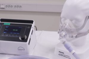 En dukke med maske og slange koblet til en ventilator