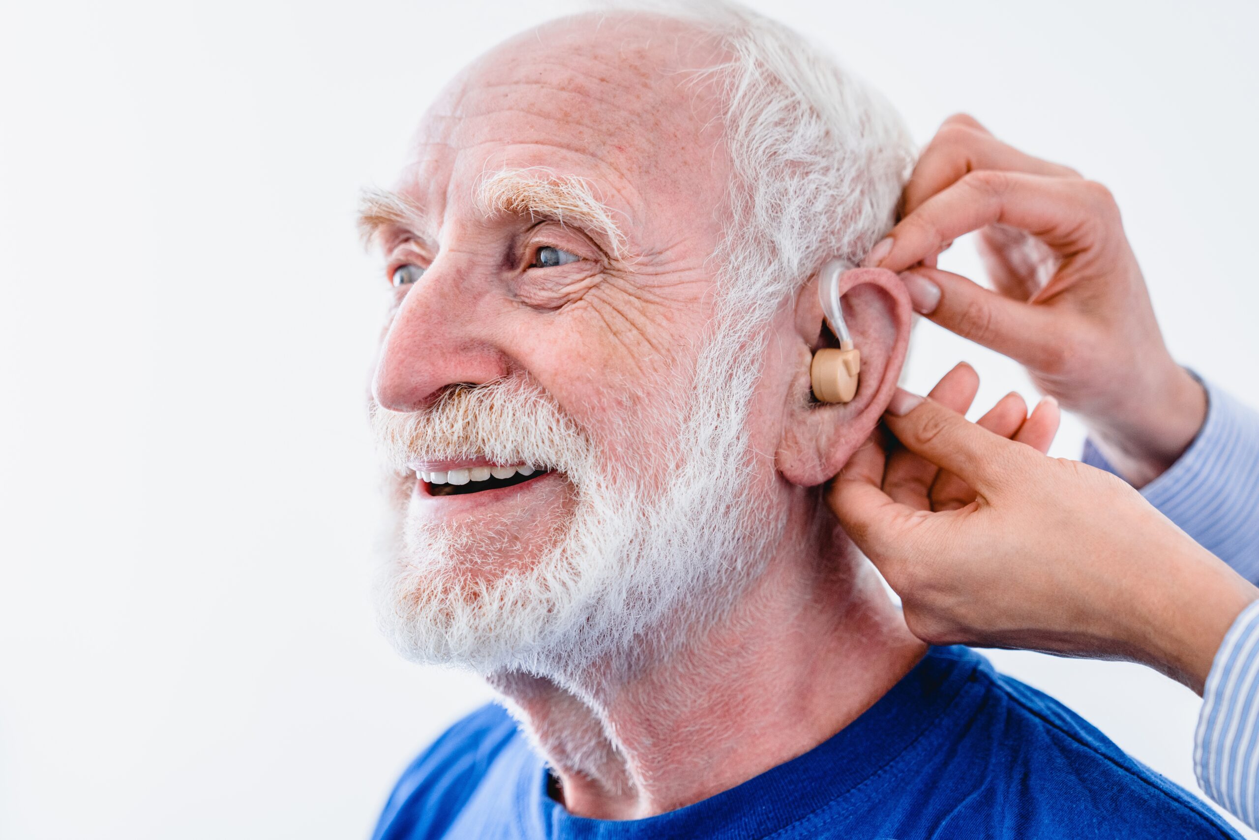 Smiling,Senior,Male,Patient,With,Hearing,Aid,Installed,By,Doctor Fotografi av eldre mann som får installert høreapparat