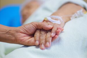 Foto: Shutterstock: En hånd som holder en pasient, som mottar behandling, i hånden
