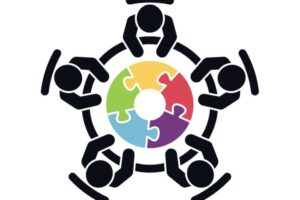 Illustrasjonsbilde av fem strekmenn sittende rundt et bord bestående av puslespillbrikker i ulike farger. Ment å illustrere møteforum.