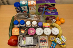 Diverse matvarer som er i posene. Brød, diverse drikke. diverse pålegg, middager, desserter, youghurt, frukt og grønnsaker.