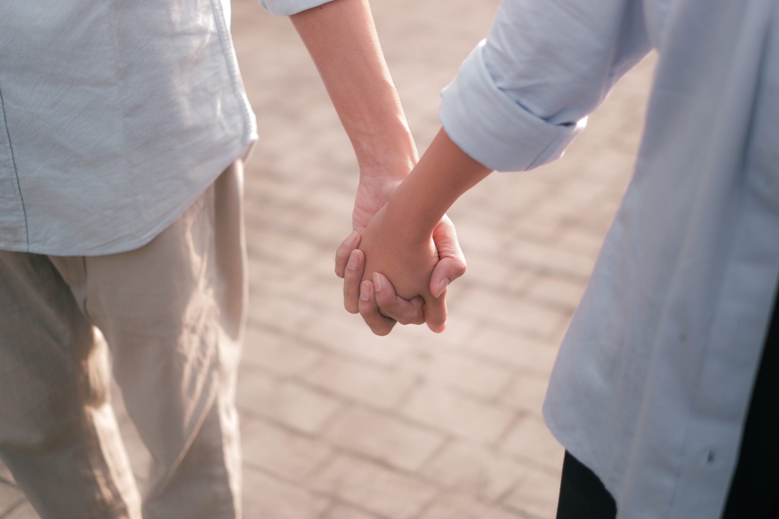 Couple,Holding,Hands,Over,Blurry,Background Fotografi av par som holder hender