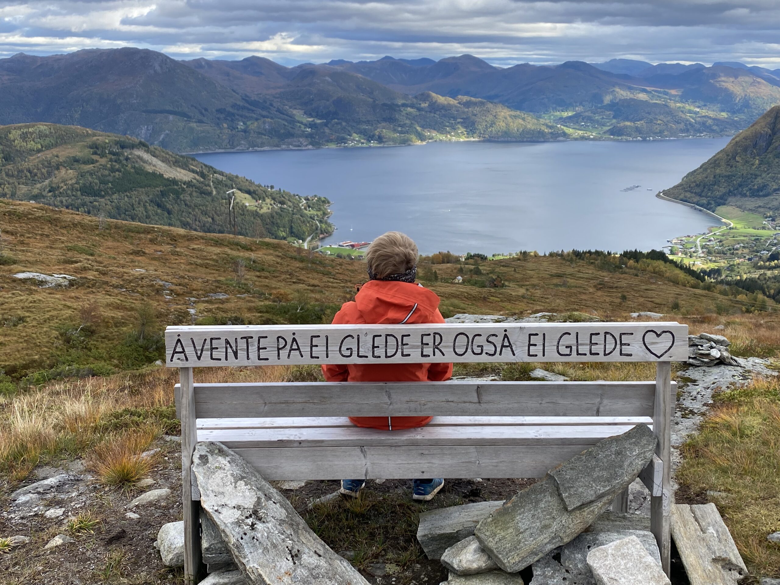 IMG_3414 fotografi av menneske sittende på benk i landlige omgivelser - på et fjell med utsikt mot innsjø