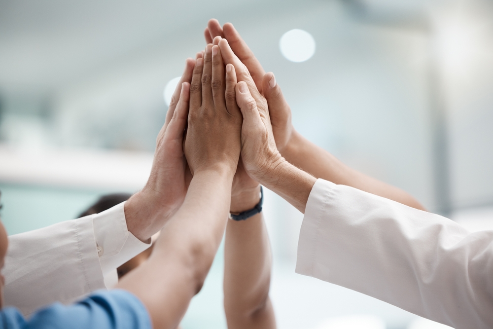 High,Five,,Teamwork,And,Doctors,Hands,In,Collaboration,For,Mission, leger som gjør high-five samtidig
