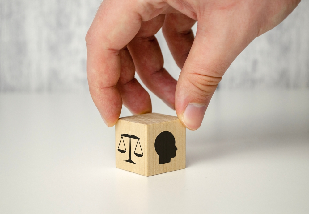 Business,Ethics,Concept.,Hand,Flip,Ethics,Inside,A,Head,Symbols Fotografi av en hånd som plasserer en terning. På terningen en vekt som symboliserer etikk, og et menneske-hode i profil
