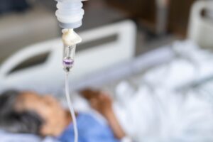 Kvinne ligger i seng med intravenøs væske