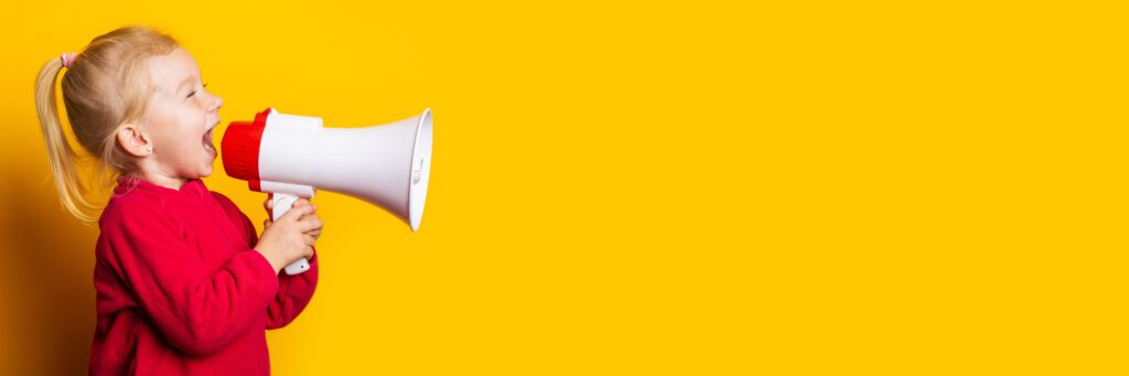 Bilde viser en jente som sier en kunngjøring i en megaphone.