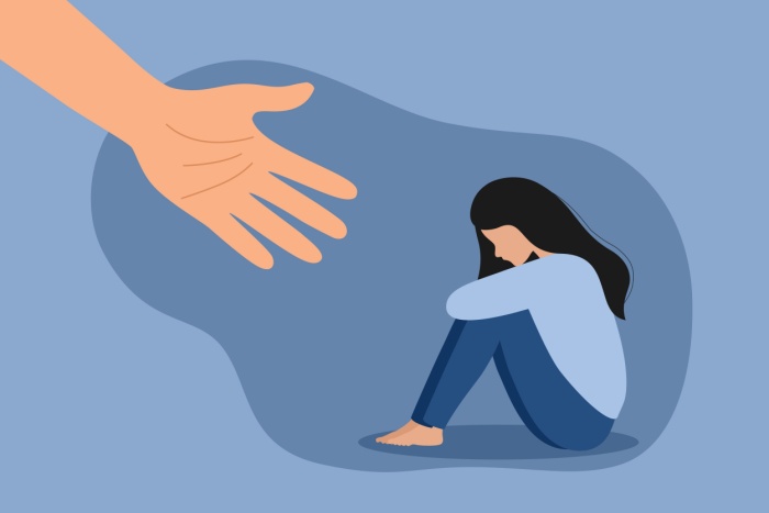 Bilde av sittende kvinne omringet av mørk blåfarge, ment å illustrere tristhet. I venstre hjørne strekkes en hudfarget hånd mot kvinnen, ment å illustrere støtte.