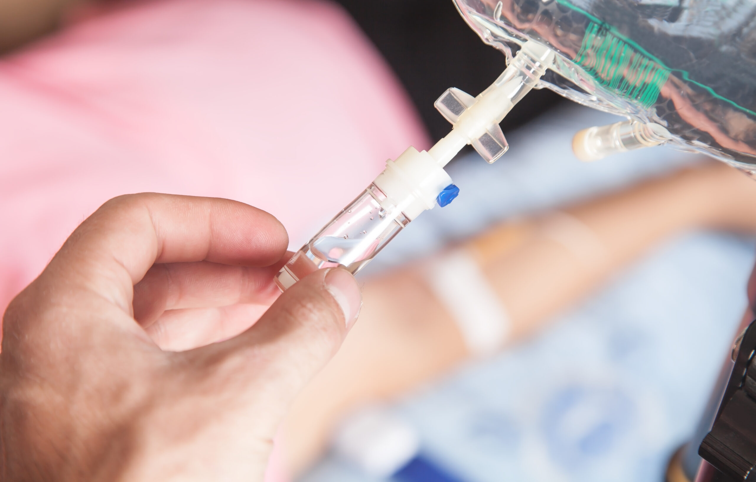 Male,Hand,Connecting,An,Intravenous,Drip,In,Home. fotografi av hånd som forbereder for bruk av infusjons-pumpe til hjemmebruk
