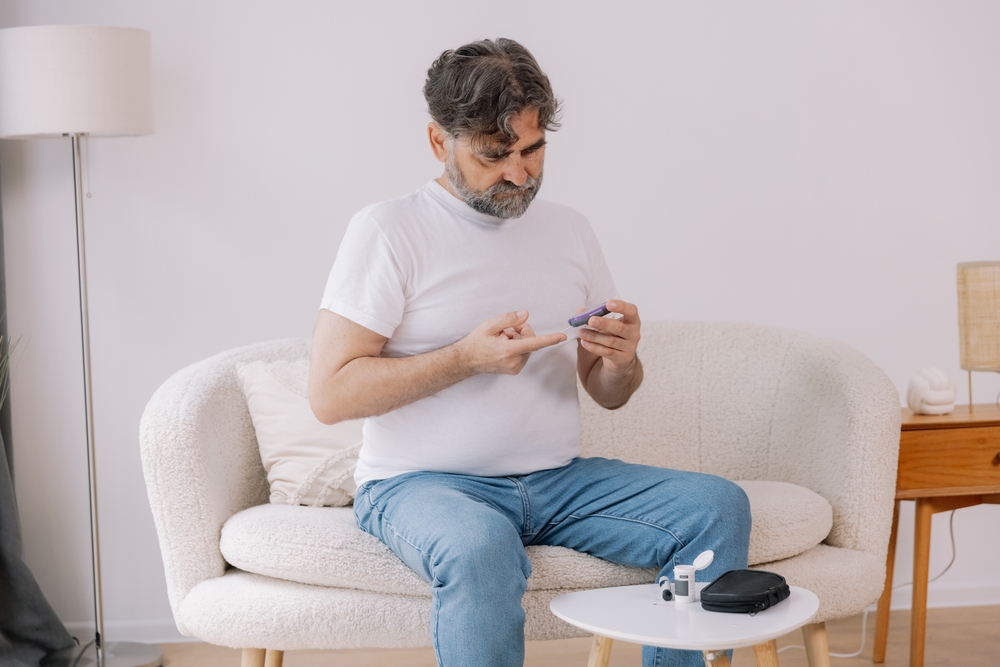 Fotografi av mann med diabetes, som måler blodsukker