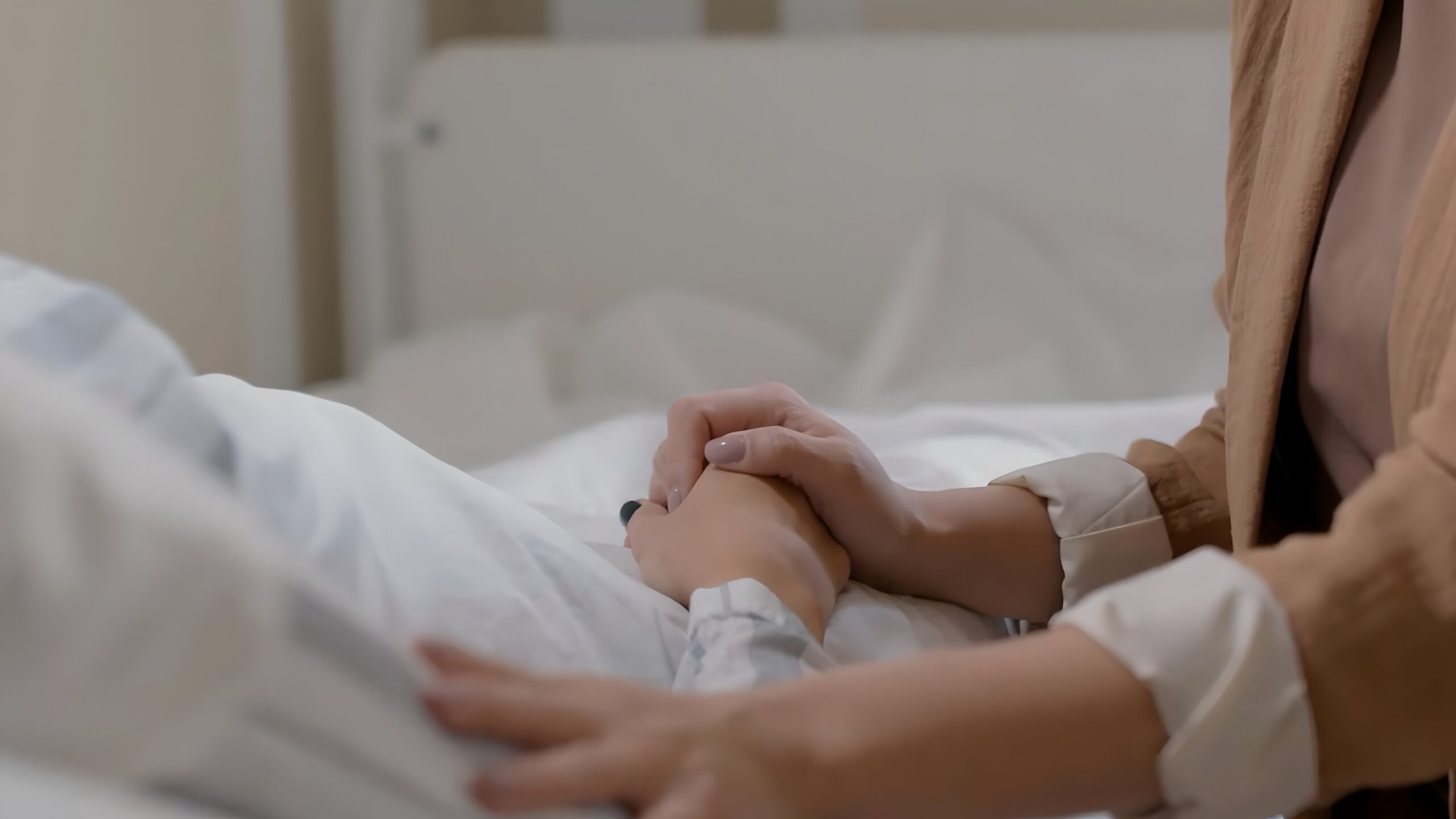 Holding,A,Hand,Titely,On,Hospital,Bed Fotografi av en situasjon med palliativ pleie, livets siste fase