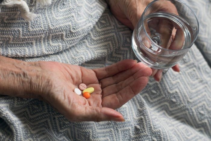 Eldre hender holder medisiner