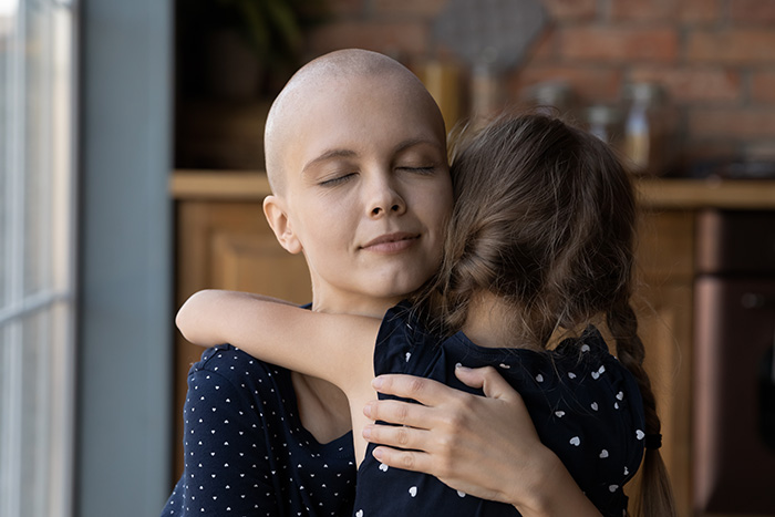 fotografi av kvinne og barn som klemmer hverandre. kvinnen er skallet