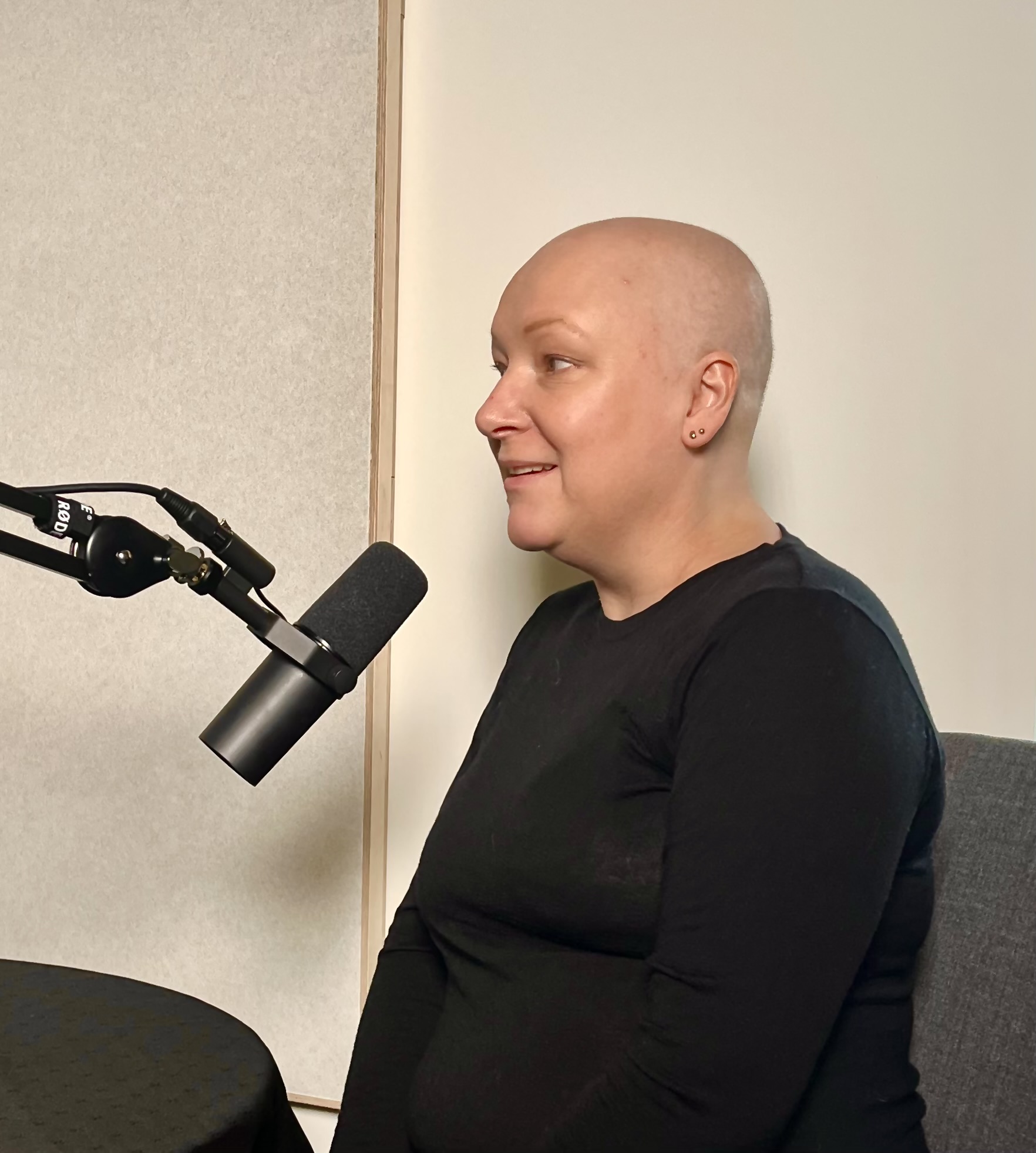 fotografi av Ida Høiby, i podkast sammenheng. Sittende foran mikrofon og hvit vegg
