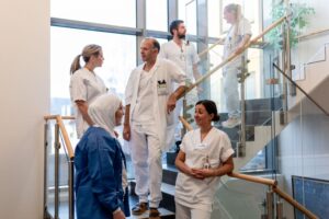 Bilde viser flere helsepersonell som står samlet i en trapp