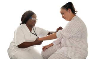 Sykepleier som skal måle blodtrykk på pasient