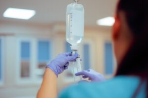 Bildet viser en person som gjør klar antibiotika som skal gis intravenøst.