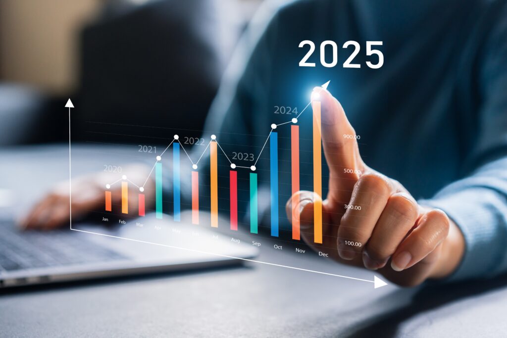 Person sitter med en PC foran seg og et diagram med årstall på, personen peker på den høyeste stolpen med året 2025. Foto