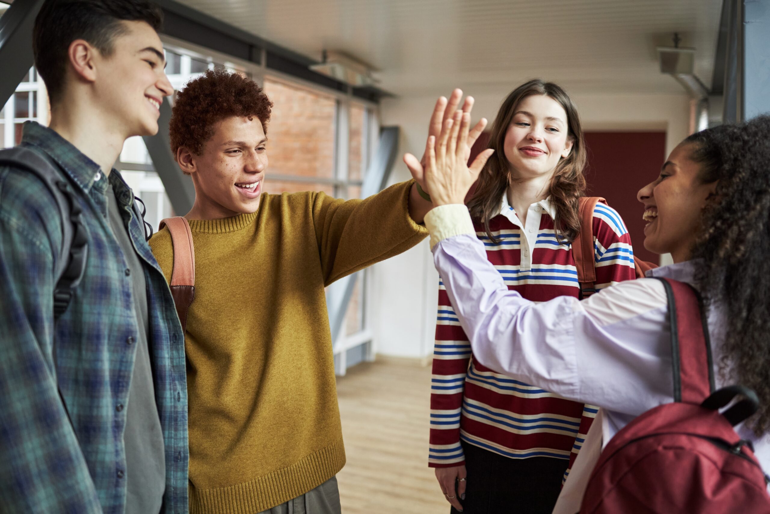 Fotografi av en gruppe unge mennesker som gjør high five