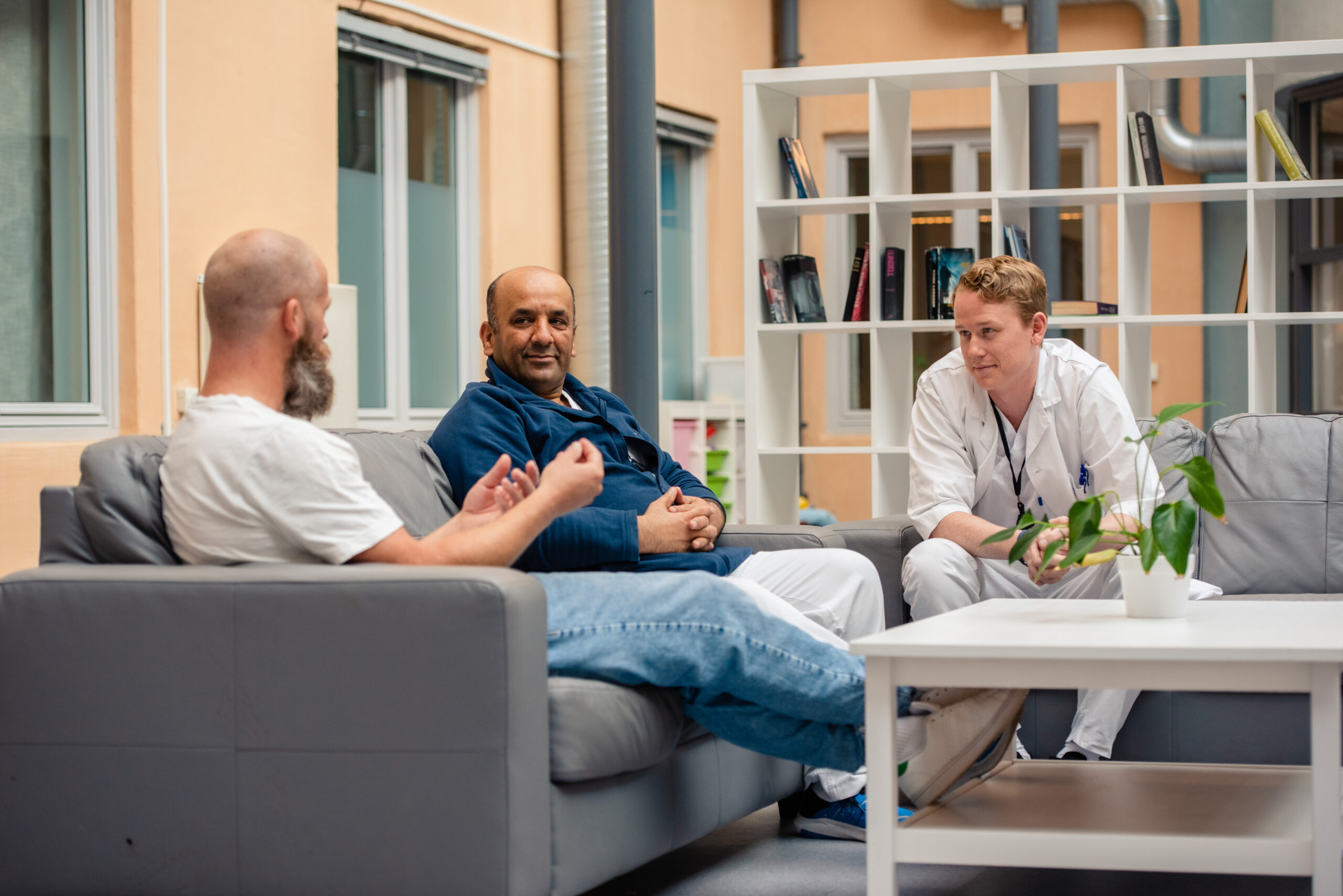 fotografi av tre menn i samtale foran et publikum, seminar-panel-situasjon