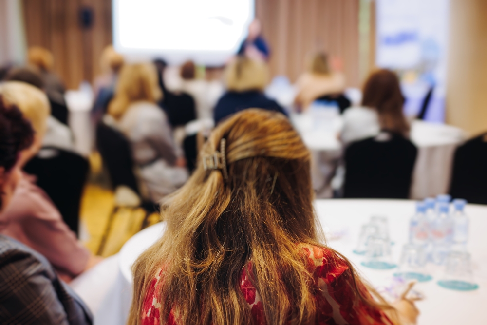 Fotografi av bakhodet til konferanse-deltagere