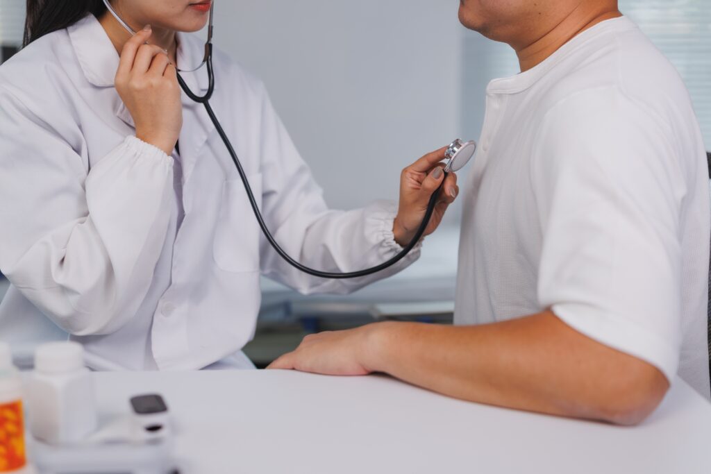 Bilde viser en lege som lytter på en pasient med stetoskop.
