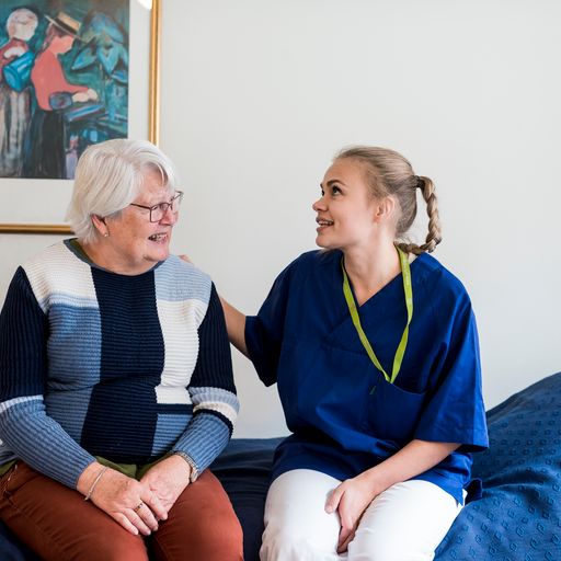 Sykepleier og pasient snakker sammen