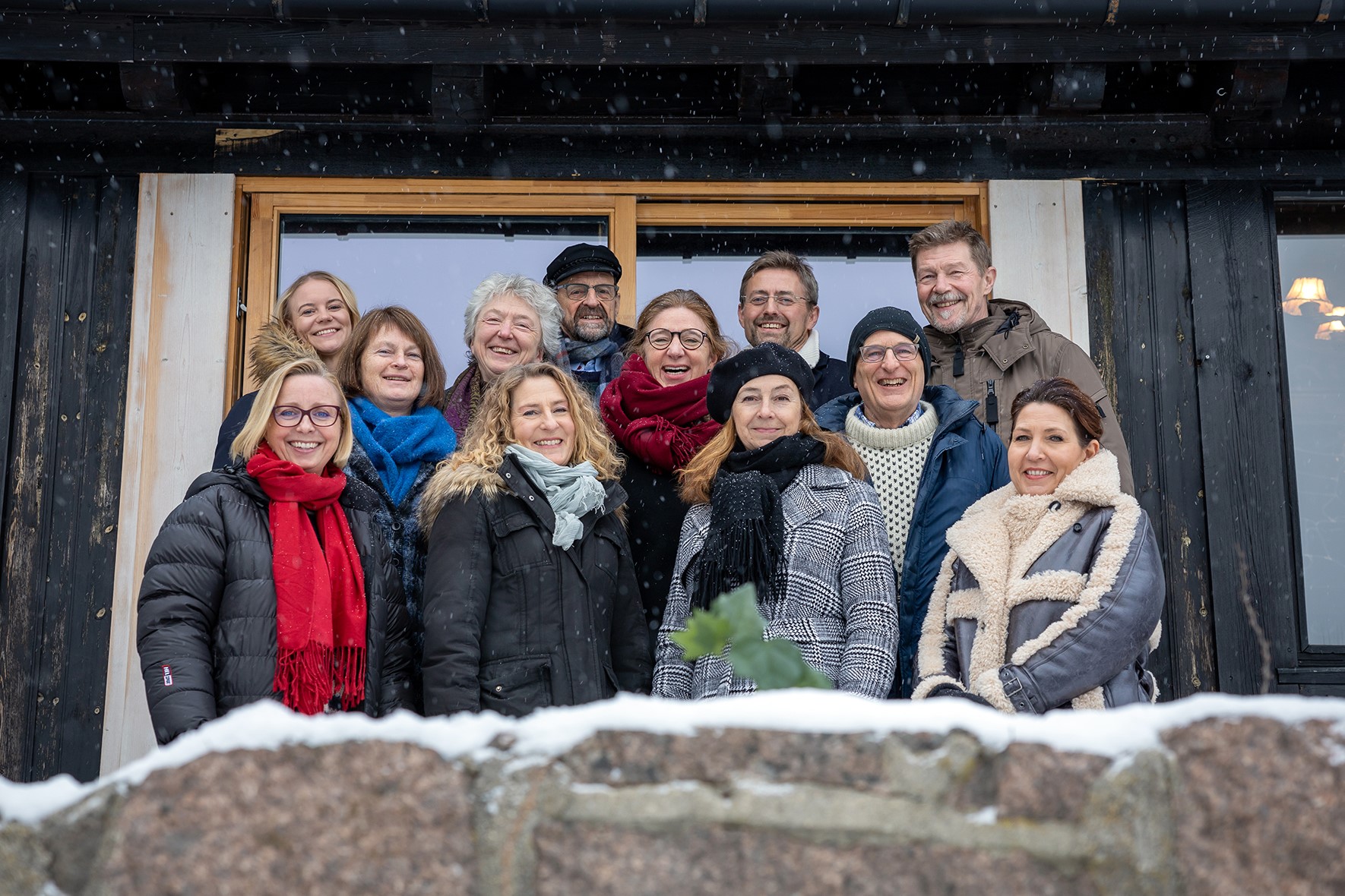 Fotografi av 4-gode vaner instruktørene foran en hytte, om vinteren