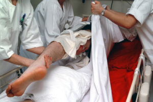 Helsepersonell som samarbeider om forflytning av pasient i seng