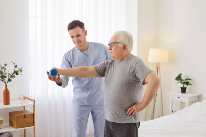 Bilde av helsepersonell som trener pasient hjemme