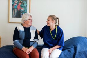 Sykepleier og pasient snakker sammen