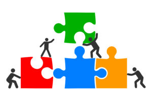 Illustrasjonen viser fire puslespillbrikker med fargene gul, blå, rød og grønn. Som flyttes sammen var 4 strek personer.