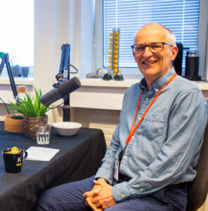 Pål Guldbrandsen under innspilling av podkast-episode, sittende foran mikrofonen. Fotografi