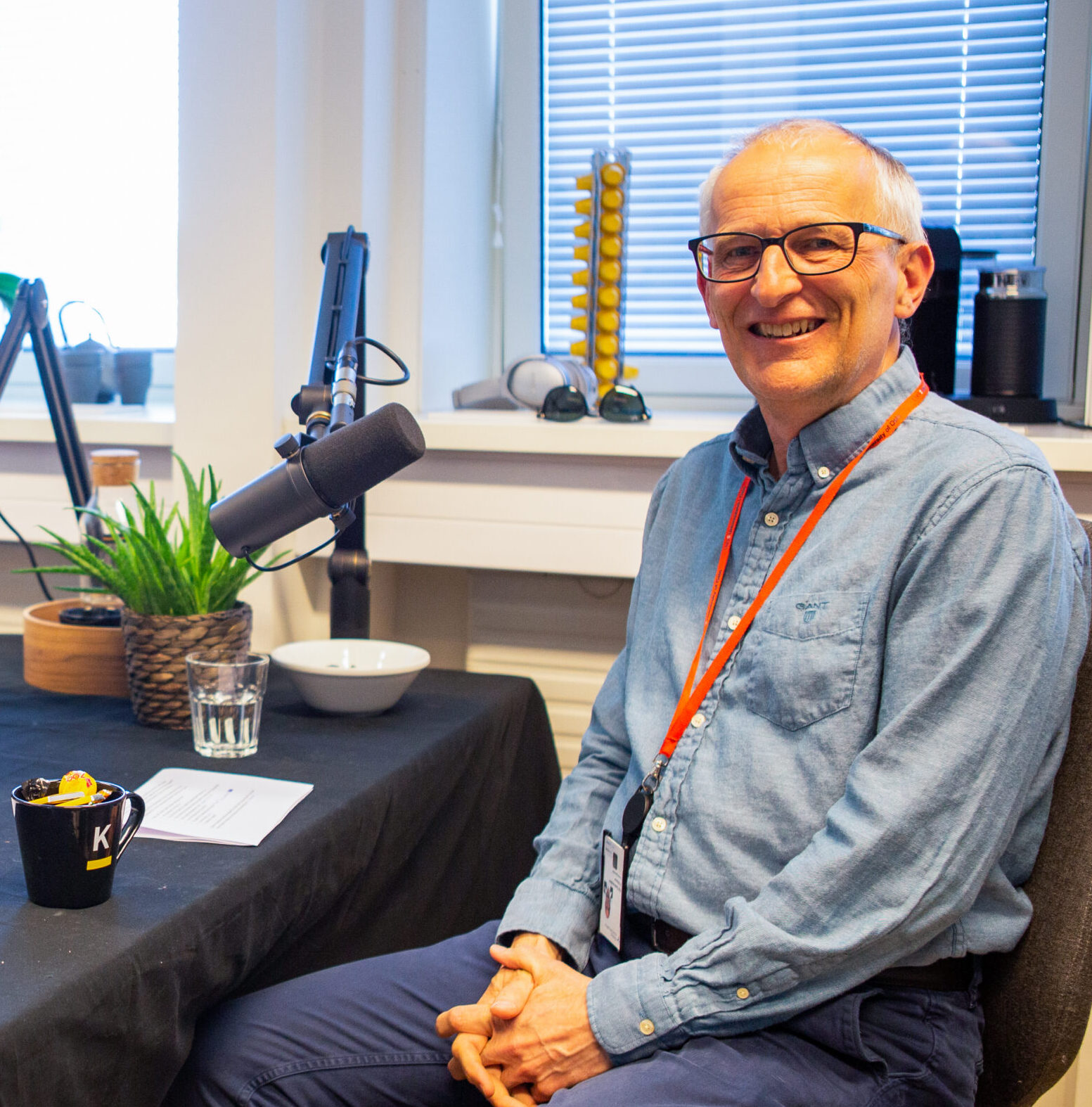 Pål Guldbrandsen under innspilling av podkast-episode, sittende foran mikrofonen. Fotografi