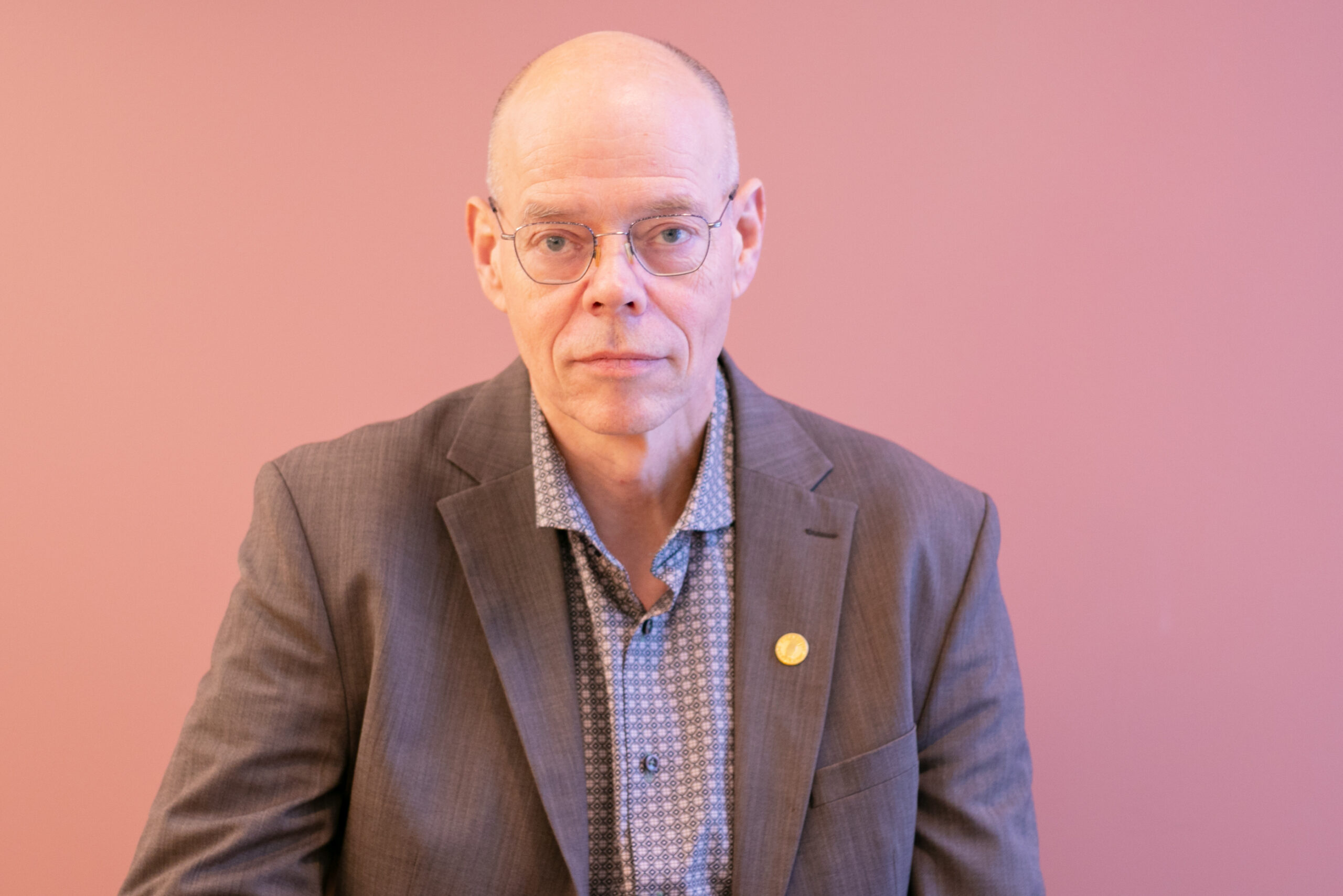 Fotografi av Edwin Schei foran rosa vegg