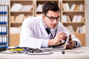 Lege undersøker pc med stetoskop. Foto: Shutterstock