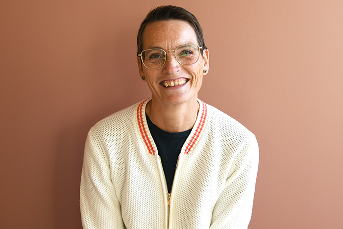 Anne-Lene-Andreasen, gjest i podkasten "helhjerta" sittende foran en beige vegg. Foto